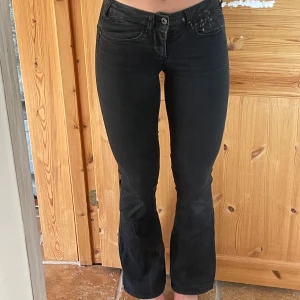 Svarta bootcut jeans low Waist - Säljer ett par svarta bootcut jeans från ONLY i modellen 25/32. Jeansen är lågmidjade med klassisk femficksdesign och har en snygg, lätt utsvängd passform nertill. Materialet är stretchigt jeans för en bekväm känsla och tight passning upptill.