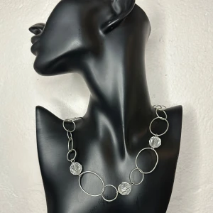 Vintagehalsband med glaspärlor och skulptural metall Retro  - Äkta vintage från 60-talet – ett iögonfallande halsband med slipade glaspärlor och stora metallringar i silvrig finish. Välbevarat och märkt “MoT”. Ca 56 cm långt, bredaste ringarna är ca 3,6 cm. Ett vackert smycke som passar både till retrostil och moderna outfits.  Prutning undanbedes, men jag erbjuder gärna bundlerabatt. Jag rensar smyckesskrin och garderob – kolla gärna mina andra annonser också!  ⸻ 