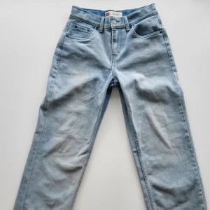 Levi's ljusblå jeans True Loose 14A - Snygga ljusblå jeans från Levi's i modellen True Loose. Klassisk femficksdesign, raka ben och normal passform. Jeansen har en ikonisk läderpatch bak i midjan och är tillverkade i slitstarkt bomullsjeans. Perfekta för en avslappnad och trendig look.