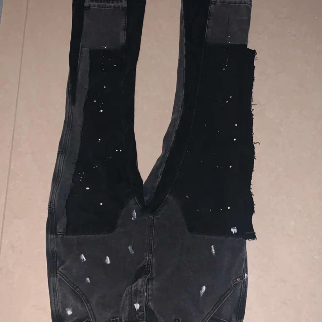 Svarta patchade jeans med råa kanter