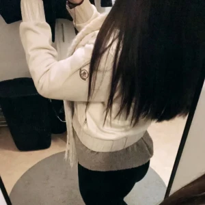 Beige pufferjacka från Moncler - Säljer en snygg beige pufferjacka från Moncler med grå detaljficka på bröstet. Jackan har långärmade stickade ärmar, quiltade partier och dragkedja framtill. Säljer den billigare då den är använd, ser dock fortfarande bra ut.