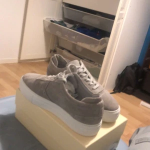 Grå mocka Arigatos skor - Gråa mocka Arigatos skor för dig som leta efter sommarskor, clean look stil. Sköna skor som är enkla att matcha till. Storlek 41 men passar även folk med 42/43. Köptes för 2500kr. Pris kan diskuteras.