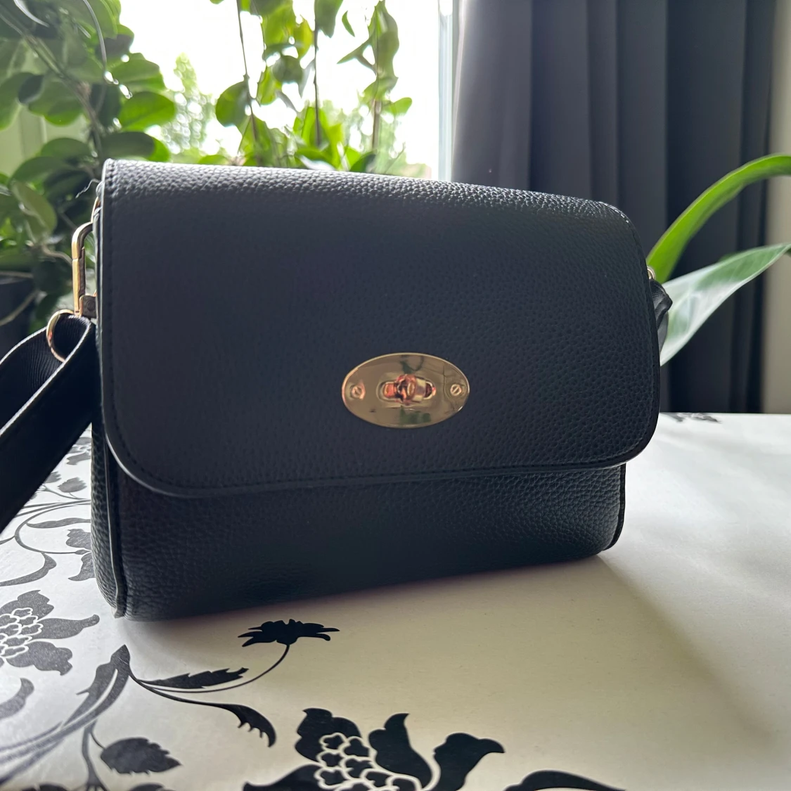 Svart axelväska i skinn med gulddetaljer