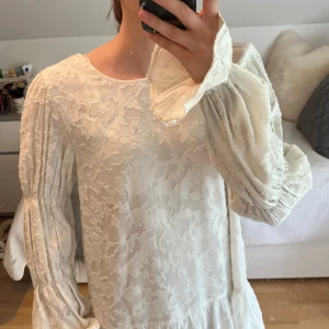 Vit kortklänning från Gina Tricot - Säljer en superfin vit kortklänning från Gina som jag inte hann lämna tillbaka. Den har långa ärmar, volang nertill och öppen rygg med knyt🌸☀️ Storleken är 36 och prislapp finns kvar. Aldrig använd🎀💗Skriv för fler frågor☺️