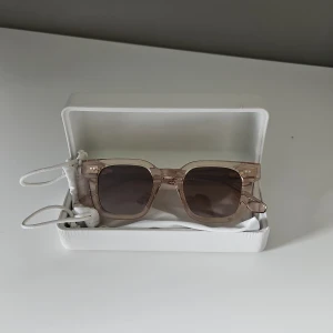 Beige fyrkantiga solglasögon Chimi - Snygga solglasögon från Chimi. De är beige och glasen är mörktonade och skyddar väldigt bra mot solen. Kommer med vit hård ask och tygpåse med en putsduk och box. Perfekta glasögon för sommaren.🔥🔥🔥 Bara skriv vid funderingar!!! Priset kan diskuteras!!!