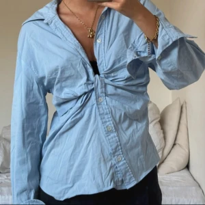 Ljusblå knytblus med knappar - Snygg ljusblå skjorta i bomull med knyt framtill och klassisk krage. Skjortan har långa ärmar och knappar hela vägen. Perfekt för en chill och trendig look. Slutsåld och väldigt eftertraktad därav priset. Använd två gånger så den är som helt ny. Priset går att diskuteras ❣️