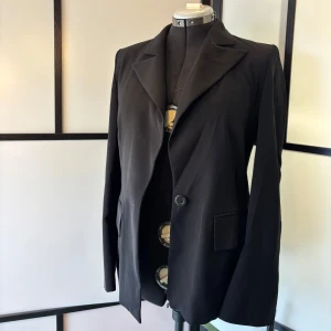 Elegant svart kavaj - Snygg och klassisk kavaj i svart från svenska designern Maria Westerlind.  Pris: 300 kr (eller högstbjudande). Nypris ligger ofta över 1000 kr i butik.  Perfekt för dig som vill ha en kvalitetskavaj som funkar både på jobbet och till fest!