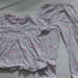 Barn pyjamas - Väl använd blommig barn pyjamas, lite trasig vid insidan av byxan, men bortsett från det är allt helt. Man får båda delarna för priset.