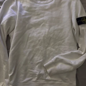 Stone island tröja  - Vita tröjan från Stone Island är riktig stilrent tröja. Säljs för att den börjar bli för liten, nyskick använd några gånger hör av er vid några frågor.