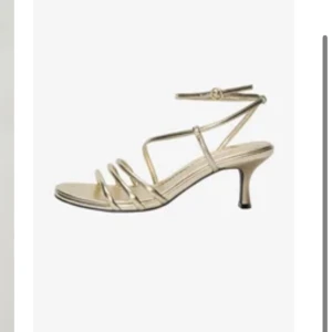 Guldiga klackskor  - Snygga klackar/sandaler i guld med smala remmar och elegant låg klack. Öppen tå och justerbar rem runt vristen💕använda en gång när jag hade bal💕
