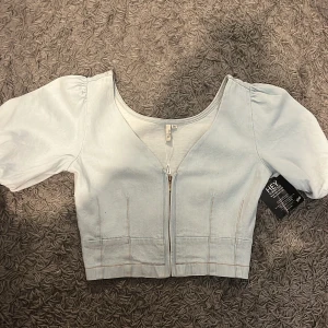 Ljusblå croppad jeanstopp - Helt ny! Säljer då den sitter för tight på mig