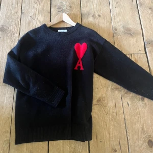 Svart stickad tröja Ami Paris med hjärta - Svart stickad tröja från Ami Paris. Jag är 181 cm lång. Inga tydliga defekter men den är i använt skick. Inte solblekt. 