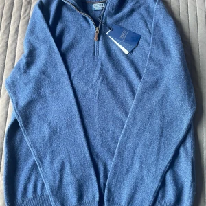 Marinblå half zip från Polo Ralph Lauren - Snygg marinblå stickad tröja från Polo Ralph Lauren med halv dragkedja och klassisk broderad logga på bröstet. Tröjan har ribbade muddar och är tillverkad i mjuk ull, perfekt för lager-på-lager under kyliga dagar. Helt ny med prislapp kvar och självklart äkta. Nypris 2800kr Fick den i födelsedagspresent men den var lite stor. Kvitto finns. Kom gärna med frågor i dm, pris kan diskuteras🤝