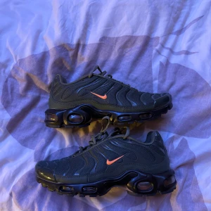 Nike Air Max Plus olivgrön/orange - Nike Air Max Plus sneakers i olivgrönt mesh och syntet med svarta detaljer och orange swoosh helt nya.Synliga Air Max-enheter i sulan och Tn-detalj undertill. Snygg vågig design och snörning framtill. Perfekta för dig som gillar streetwear och unika färgkombos.