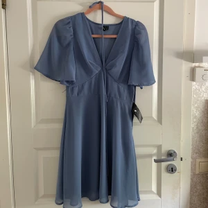 Blå klänning  - Säljer denna jättesöta klänning som ej används längre. Endast använd en gång! Klänningen kommer med ett ”skärp” till då du kan knyta åt midjan💕