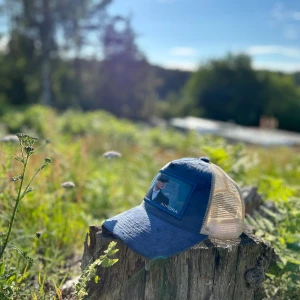 Blå och beige keps med tryck från Aurora - Snygg keps i blått och beige med mesh-bakstycke och ett tryckt motiv framtill. Märkt med Aurora på framsidan. Perfekt accessoar för soliga dagar.