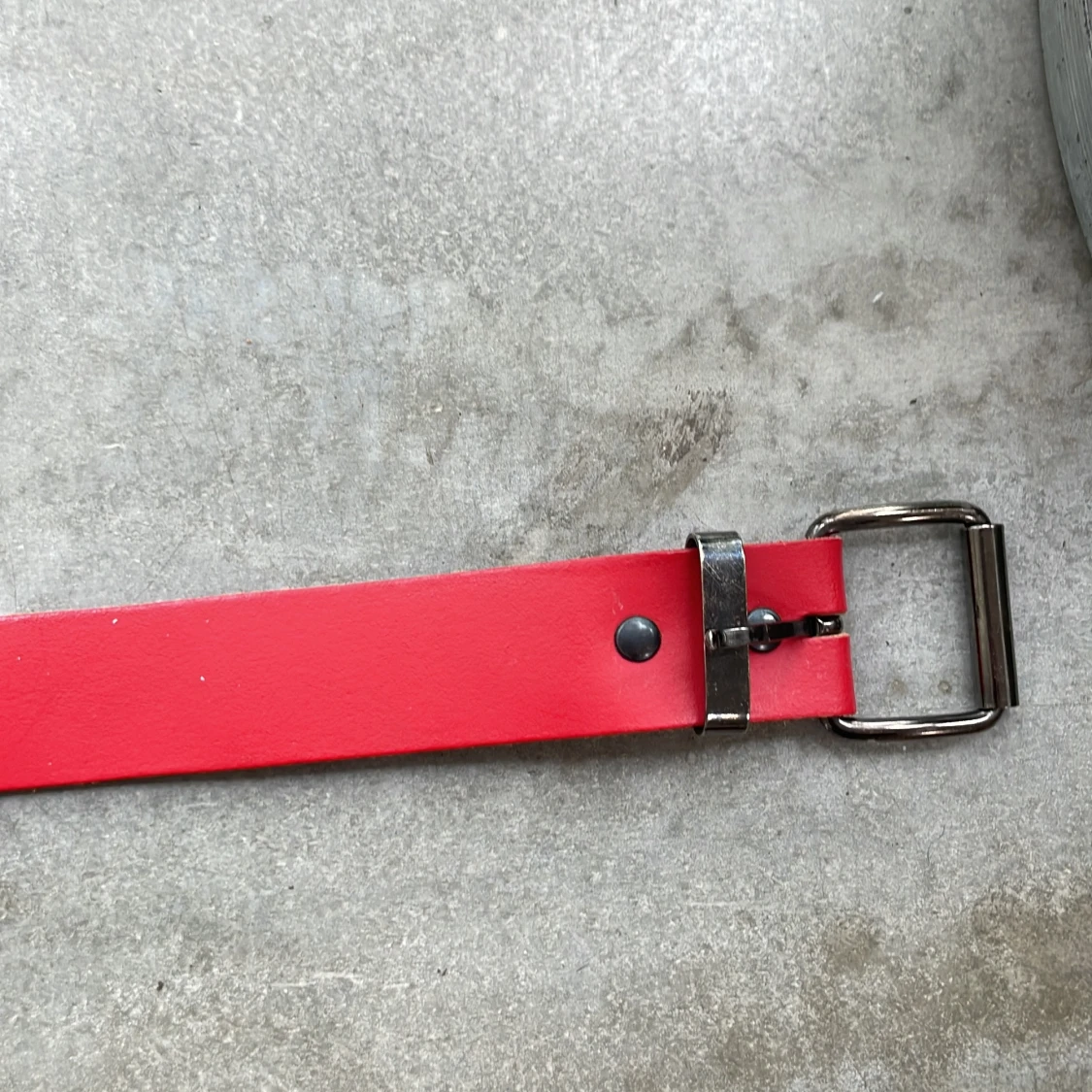 Rött bälte med silverfärgat spänne