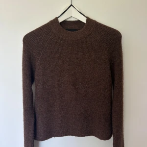 Brun stickad tröja från Pieces - Mysig brun stickad tröja från Pieces med rund halsringning och långa ärmar. Tröjan har en enkel och klassisk design med rak passform och mjukt material som passar perfekt till kyligare dagar. Jag köpte den för 299 och säljer den nu då jag inte har använt den och jag har för mycket kläder i min garderob:).