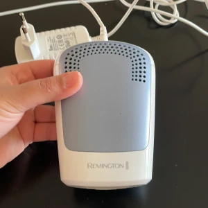 Remington IPL hårborttagningsapparat - Elektrisk IPL hårborttagningsapparat från Remington i vitt och ljusblått. Kommer med sladd och adapter. Perfekt för långvarig hårborttagning hemma. Smidig och enkel att använda med rektangulärt ljusfönster.