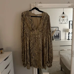 Zebramönstrad långärmad klänning med knappar - Säljer denna snygga Adoore klänningen. Stl 42 sitter som 38/40