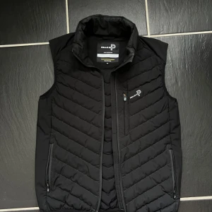 Svart dunväst från Pelle P - Riktigt stilig väst från Pelle P i väldigt bra skick. Prefekt för sommarkvällarna. Nypris 1600kr.