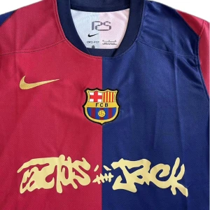 FC Barcelona x Travis Scott Home Jersey (fan edition) - Säljer en FC Barcelona x Travis Scott matchtröja i röd och blå med klubbmärke på bröstet och Nike-logga i guld. Tröjan har korta ärmar och är tillverkad i ett lätt, ventilerande material. Unik design med Travis Scott-grafik på framsidan.