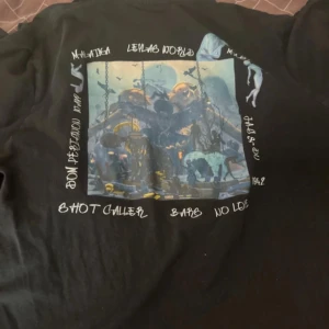 Antwan merch - Svart långärmad tröja från Leylas World med tryck både fram och bak. Framsidan har texten 'Leylas World' i vitt och baksidan har ett stort färgglatt motiv med olika detaljer och text runtom. .