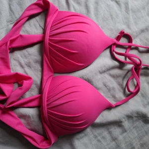 Rosa bikiniöverdel med knyt - Säljer en snygg rosa bikiniöverdel med vadderade kupor och knyt i nacken och ryggen.