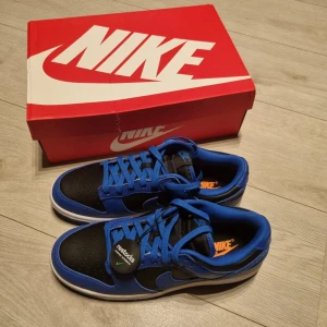 Nike Dunk Hyper cobalt blå och svarta sneakers - Säljer ett par Nike Dunk Low sneakers i blått. Skorna har klassisk snörning, rund tå och platt sula. Perfekta för dig som gillar streetwear och vill ha en stilren look med färg. Skorna är helt nya aldrig använda! Kom gärna med prisförslag