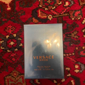 Versace Eros Eau de Toilette 100 ml - Versace Eros Eau de Toilette för herr, 100 ml. Parfymen kommer i en lyxig blågrön rektangulär kartong med guldiga detaljer och klassiskt Versace-mönster. En ikonisk doft med fräsch och maskulin karaktär.