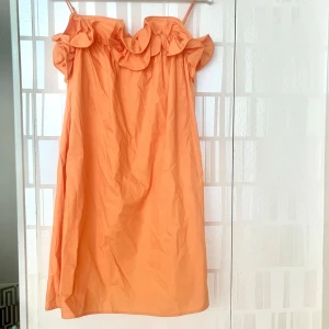 Orange/persikofärgad volangklänning från H&M - Superfin klänning från H&M med volangdetaljer upptill med smala axelband. Klänningen är slutsåld!🧡💛