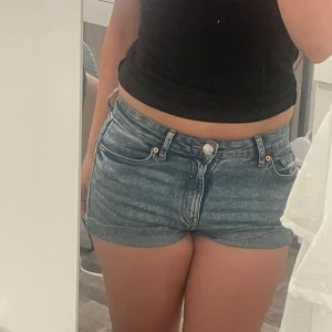 Blå jeansshorts - Säljer ett par blå jeansshorts med klassisk femficksdesign och uppvikta benslut. Shortsen har låg/mid midja och en tight passform som sitter snyggt på kroppen. Perfekta för varma sommardagar. De är avklippta från vanliga jeans! BARA POSTNORD⚠️