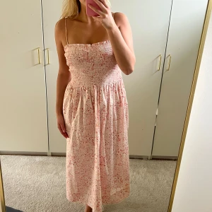 Ljusrosa blommig klänning med smock - Superfin klänning som bara är använd ett fåtal gånger. Perfekt till midsommar eller som vardagsklänning. Banden är avtagbara så man kan använda den som en bandeuklänning💕💕☀️☀️