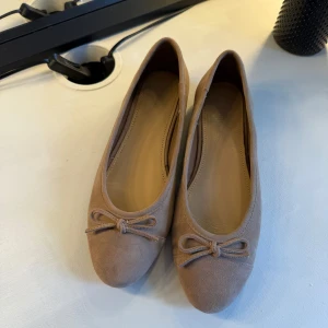 Beige ballerinaskor i läder  - Ett par ballerinaskor i äkta läder (mocka). De är från H&Ms premium kollektion och är använda en gång. 