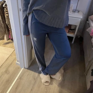 Blå Adidas mjukisbyxor med vita ränder - Säljer ett par blå mjukisbyxor från Adidas i storlek xs. Skriv om du har några frågor!💕