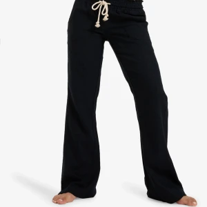 Svarta linnebyxor med snörning - Svarta linnebyxor med raka ben och beige snörning i midjan. Byxorna har en avslappnad passform och resår i midjan för extra komfort. Perfekta för en chill och stilren look.