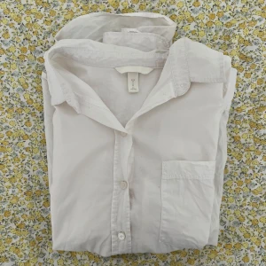 Vit skjorta  - Klassisk vit skjorta från H&M med lång ärm och en bröstficka. Storlek M 