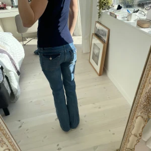 Blå bootcut jeans från Nelly - Säljer ett par klassiska blå bootcut jeans från Nelly med låg midja och snygga fickdetaljer. Jeansen har en normal passform och är tillverkade i bomull med lite stretch för extra komfort. Perfekta till din vardagsstil! Dem var lite för långa när jag köpte dem så sydde upp dom lite hos en skräddare, den nya innebenslängden är 76 cm. 💗Pris kan diskuteras💗