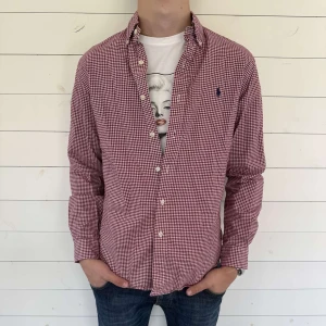 Rutig vinröd skjorta från Ralph Lauren M - Säljer en snygg vinröd skjorta från Ralph Lauren i slim fit-modell.  Säljer den för endast 399kr, skriv vid frågor eller funderingar! 