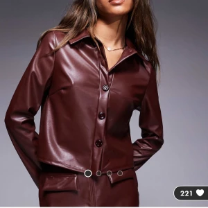 Brun skjorta i läderimitation  - Brun skjorta i läderimitation från Asos. Helt ny med prislapp kvar, del av set. (Säljer även kjolen) Köpt för 409kr.