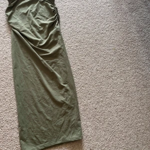 Olivgrön långkjol från Pull&Bear - Säljer en olivgrön långkjol från Pull&Bear i mjuk bomull. Perfekt för varma dagar eller att styla med accessoarer.