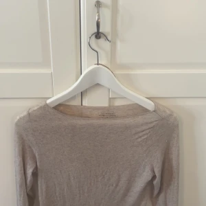 Beige långärmad topp från Intimissimi - Säljer en tunn och mjuk beige långärmad topp från Intimissimi i kashmirblandning. Perfekt att ha som lager under andra plagg eller bara som den är. Enkel och stilren design med rund halsringning.