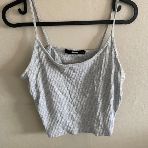 Ljusgrå ribbad linnetopp från Bik Bok - Säljer en ljusgrå ribbad linnetopp från Bik Bok med smala axelband. Perfekt för varma dagar eller som lager under en skjorta. Enkel och stilren design som passar till mycket.