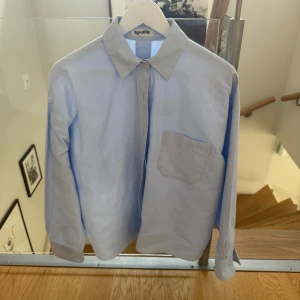 Ljusblå skjorta från Djerf Avenue - Säljer en stilren ljusblå skjorta från Djerf Avenue i storlek M. Skjortan är i mycket bra skick🫶🏼