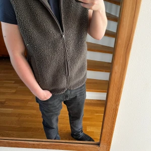 fleeceväst -  brun/grön fleeceväst med hel dragkedja framtill och två fickor.