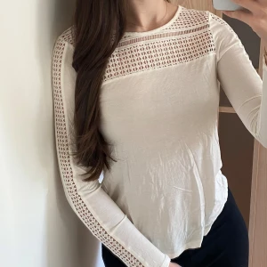 Vit topp - Vit långärmad topp med utskurna detaljer. Oanvänd. 