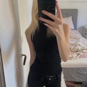 Svart ärmlös polotopp - Snygg svart ärmlös polotopp med tight passform. Helt ny och aldrig använd. Från Zara i storlek S, men passar även Xs.