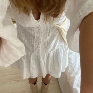 Vit Zara klänning - Superfin vit kortklänning med v-ringning, långa ärmar och knappar framtill💕 Funkar perfekt till midsommar, student eller skolavslutning! Det är en M men passar mig som brukar ha xs-S, den är smått insydd i ryggen för att midjan ska vara mer figurnära, endast några stygn som kan tas bort (utan att bli defekter) om det önskas💕 (lånade bilder)