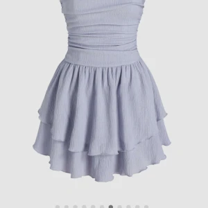 Ljusblå axelbandslös volangklänning - Supersöt ljusblå klänning med axelbandslös design och dubbla volanger i kjolen. Smickrande passform med rynkade detaljer upptill och markerad midja. Perfekt för sommarens alla tillfällen!