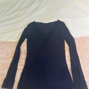 Svart långärmad topp med spetsdetaljer - Säljer en marinblå långärmad topp från Intimissimi!bra skick och inga hål vad jag har sätt!💕